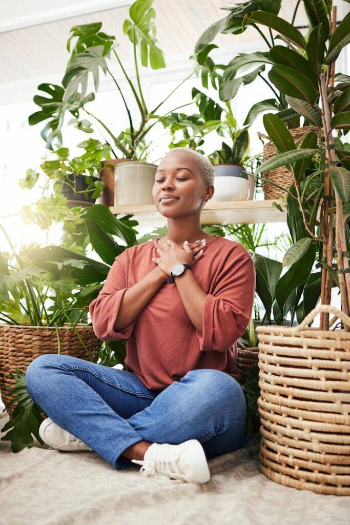 Woman Sat On The Floor Next To Plants Relaxing